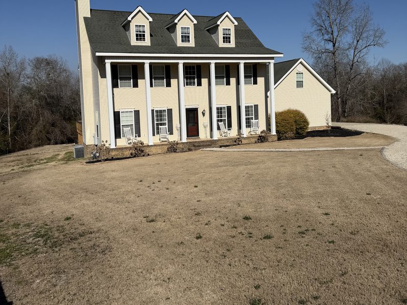 Brown, dormant lawn in front of a home — the kind of yard the Weed Wipeout Protocol transforms